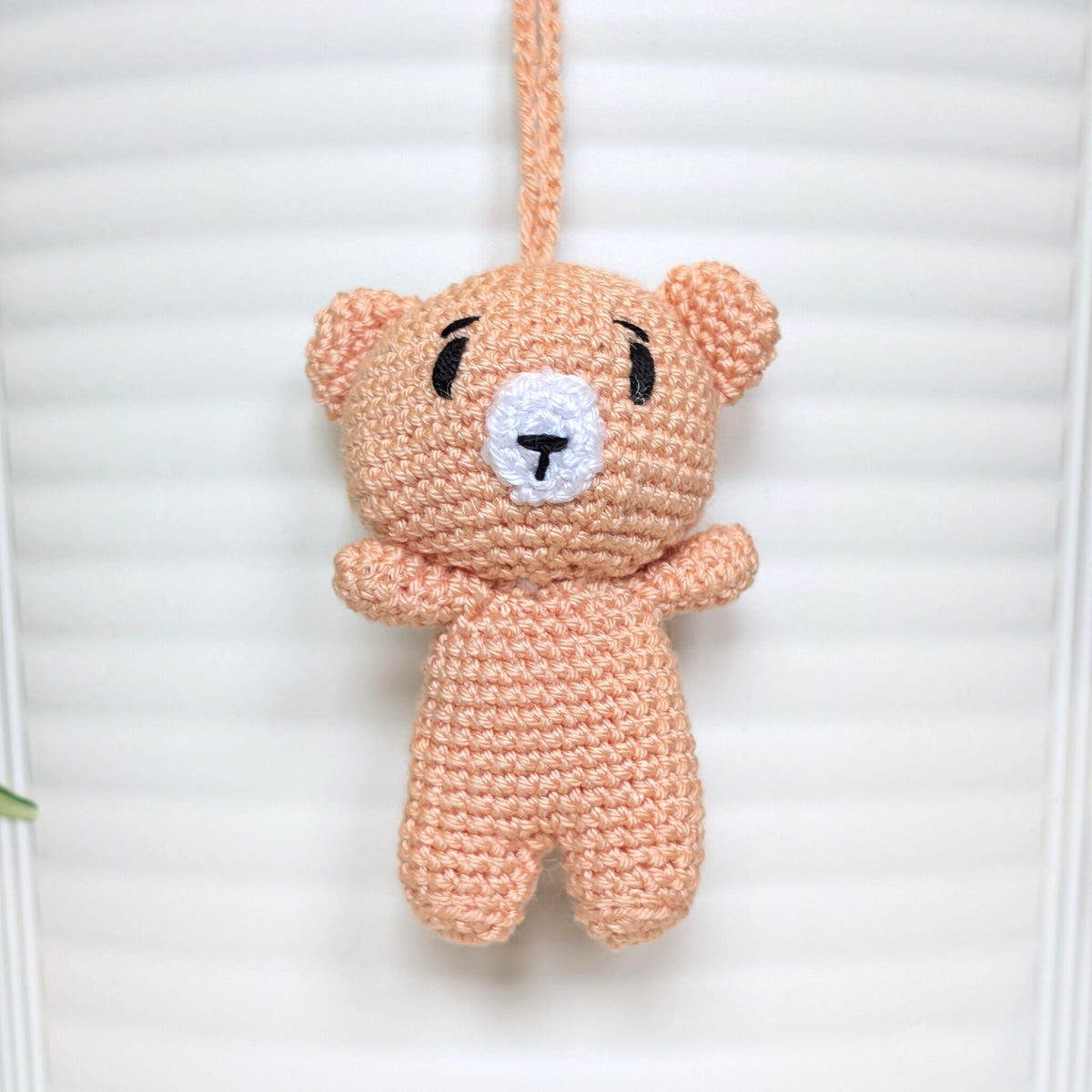 Peach colored crocheted mini teddy bear bag charm with string