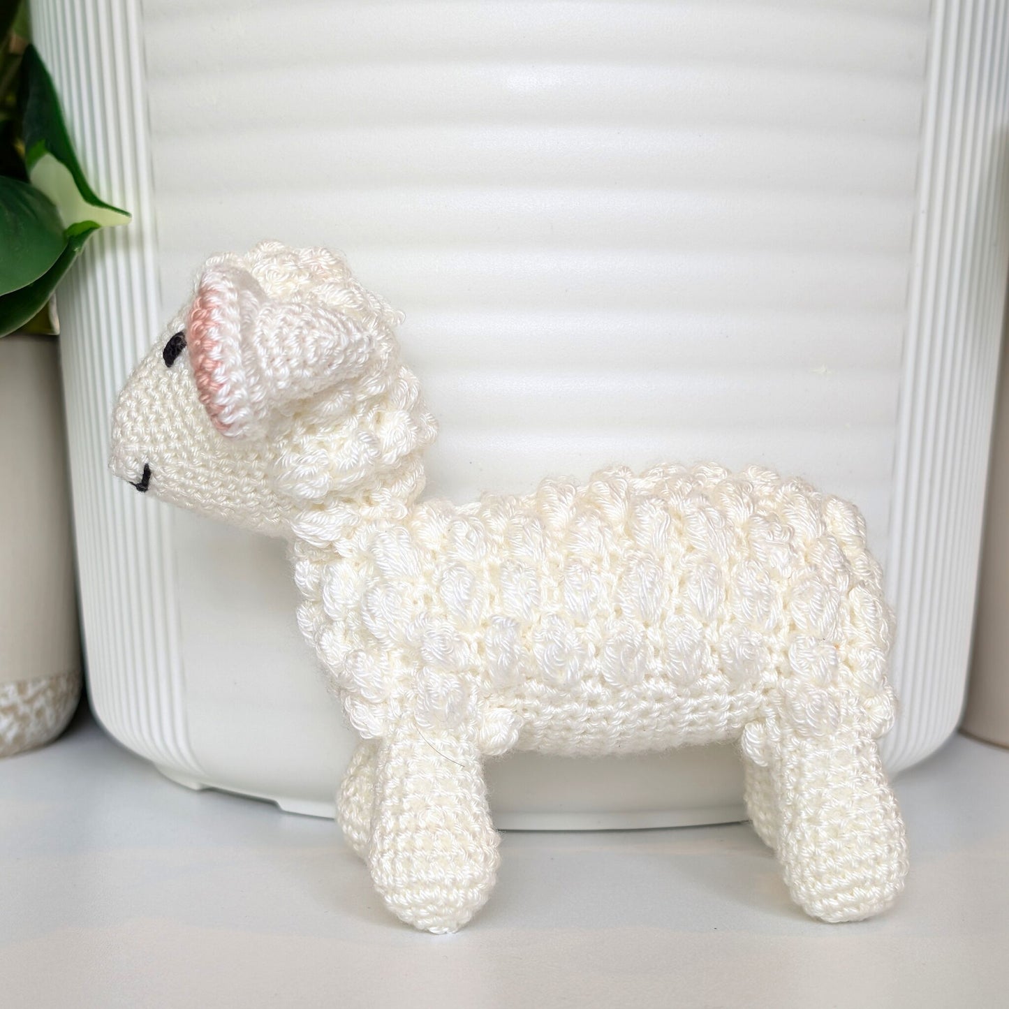 Side view of crocheted baby lamb with ivory ears