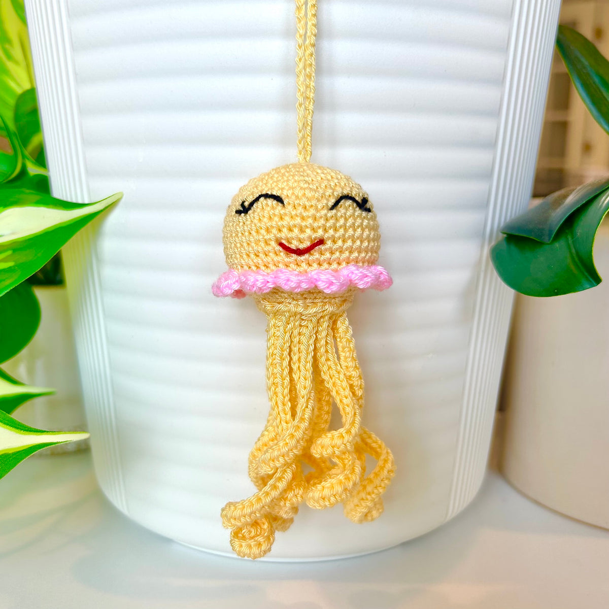 Crocheted light yellow jellyfish bag charm with pink trim