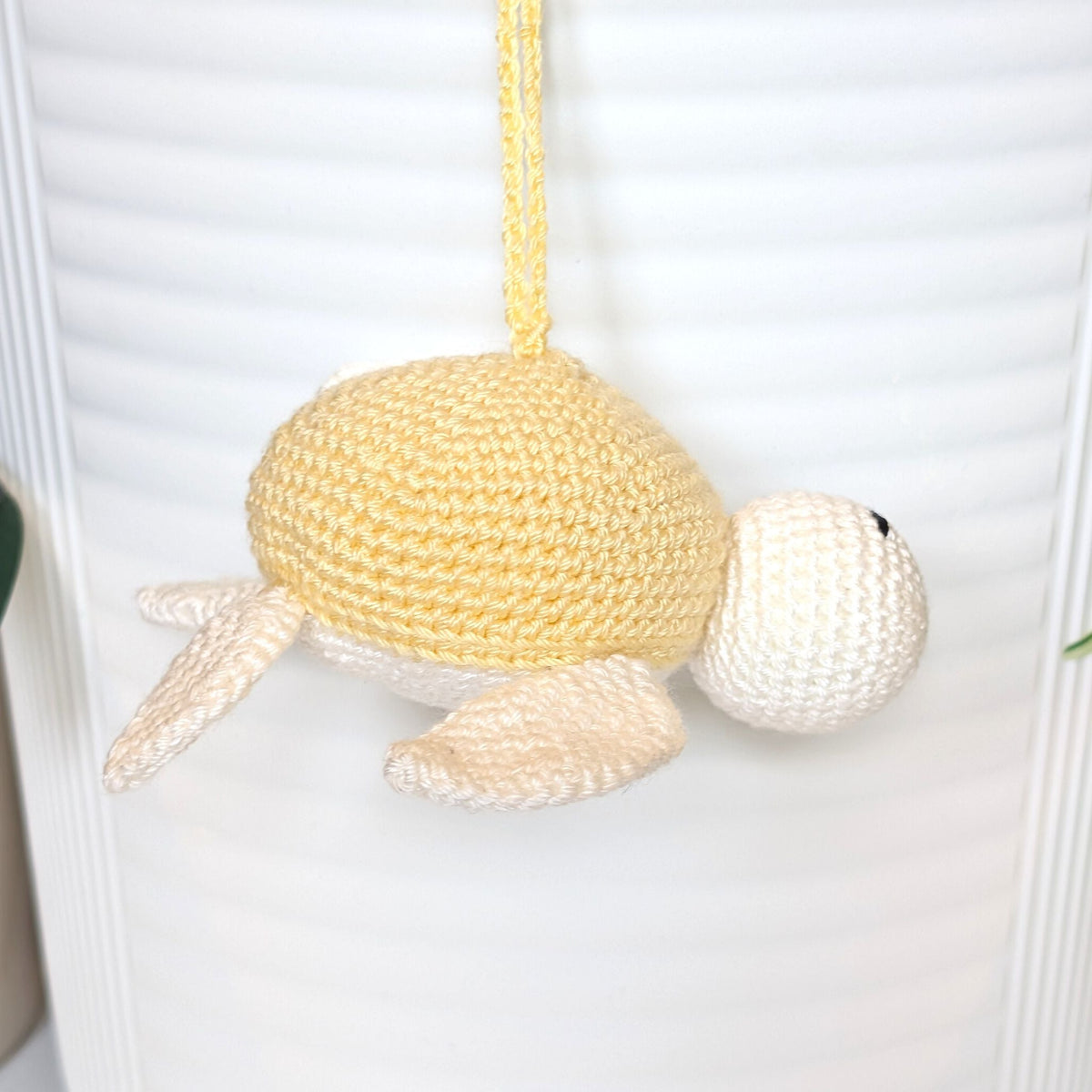 Crocheted sea turtle charm keychain with a dusty creme brulee colored shell