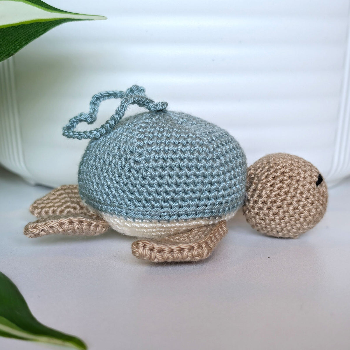 Crocheted Sea turtle with light seafoam blue shell with beige body and a string