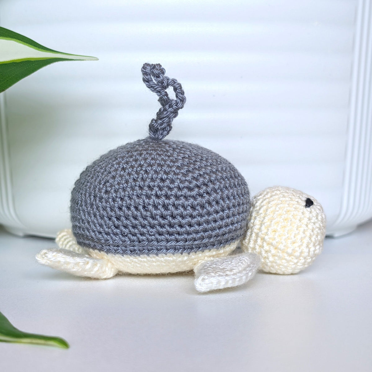 Crocheted sea turtle charm keychain with a dark gray shell