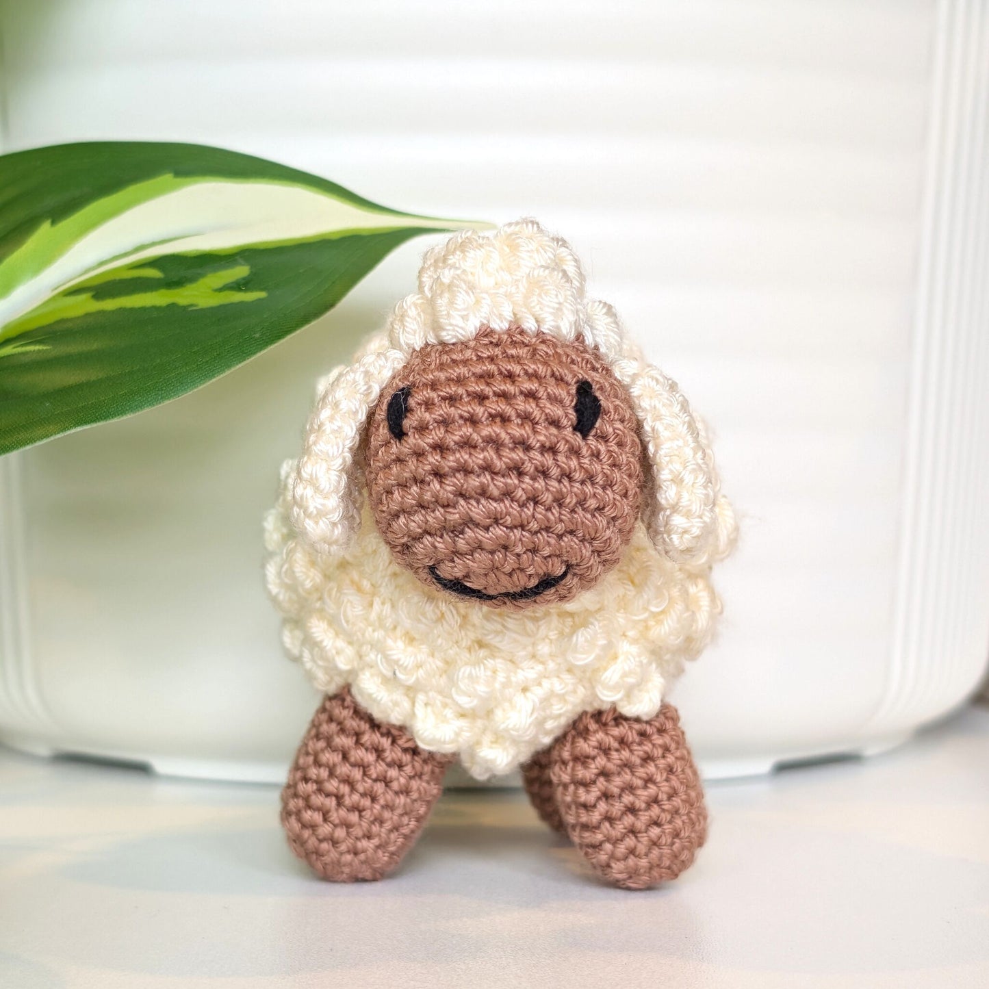 Front view of crocheted cream fleece sheep plush with oatmeal body