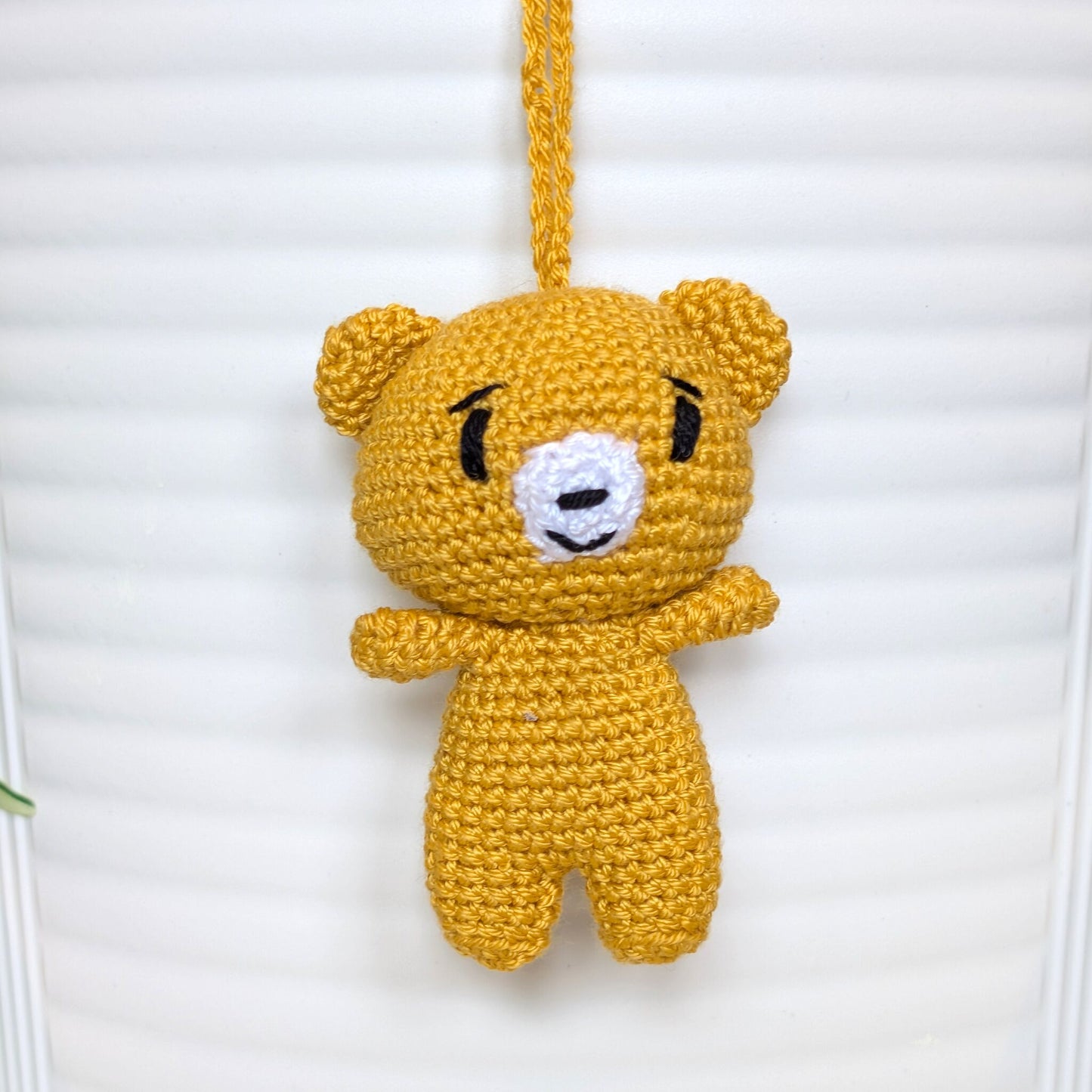 Marigold colored crocheted mini teddy bear bag charm with string
