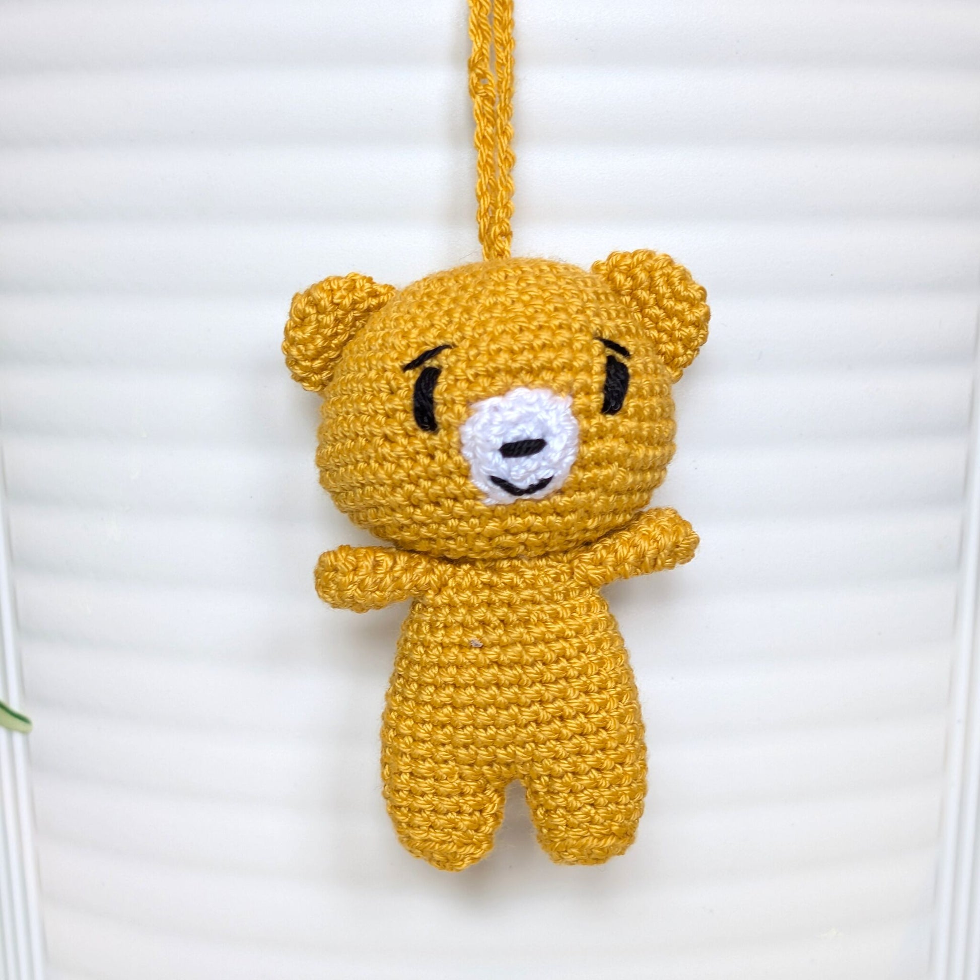 Marigold colored crocheted mini teddy bear bag charm with string