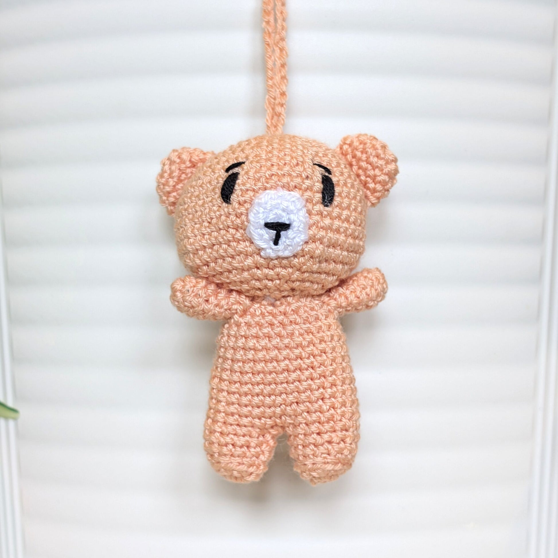 Peach colored crocheted mini teddy bear bag charm with string