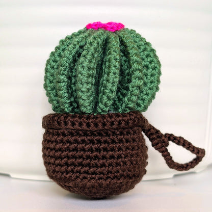 Crocheted golden barrel cactus in a brown pot with a hot pink flower and a string