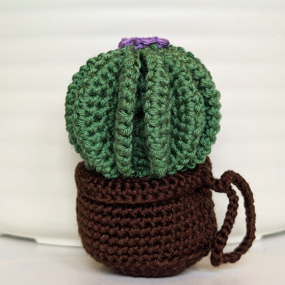 Crocheted golden barrel cactus in a brown pot with a lavender flower and a string