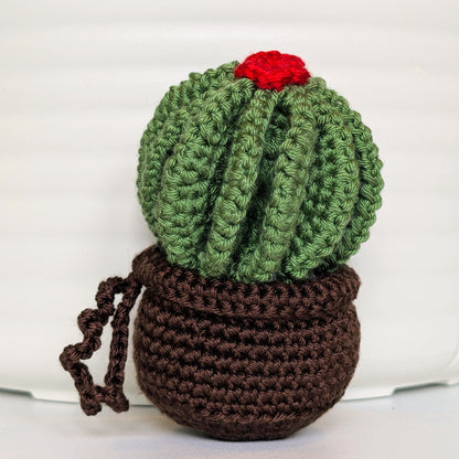 Crocheted golden barrel cactus in a brown pot with a red flower and a string