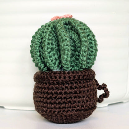 Crocheted golden barrel cactus in a brown pot with a soft melon flower and a string