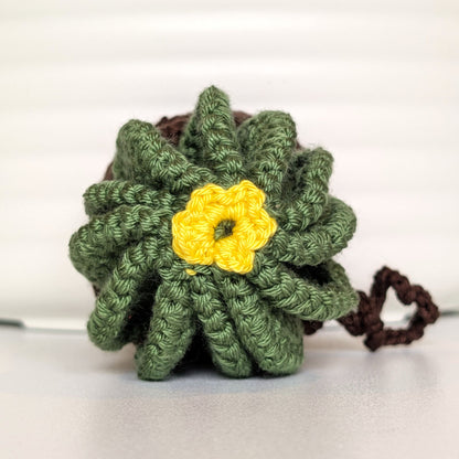 Crocheted golden barrel cactus in a brown pot with a yellow flower