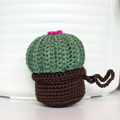 Crocheted moon cactus charm with a hot pink flower and attached string, potted in a brown pot