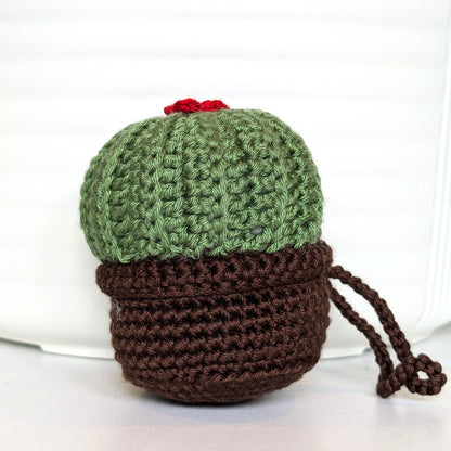 Crocheted moon cactus charm with a red flower and attached string, potted in a brown pot