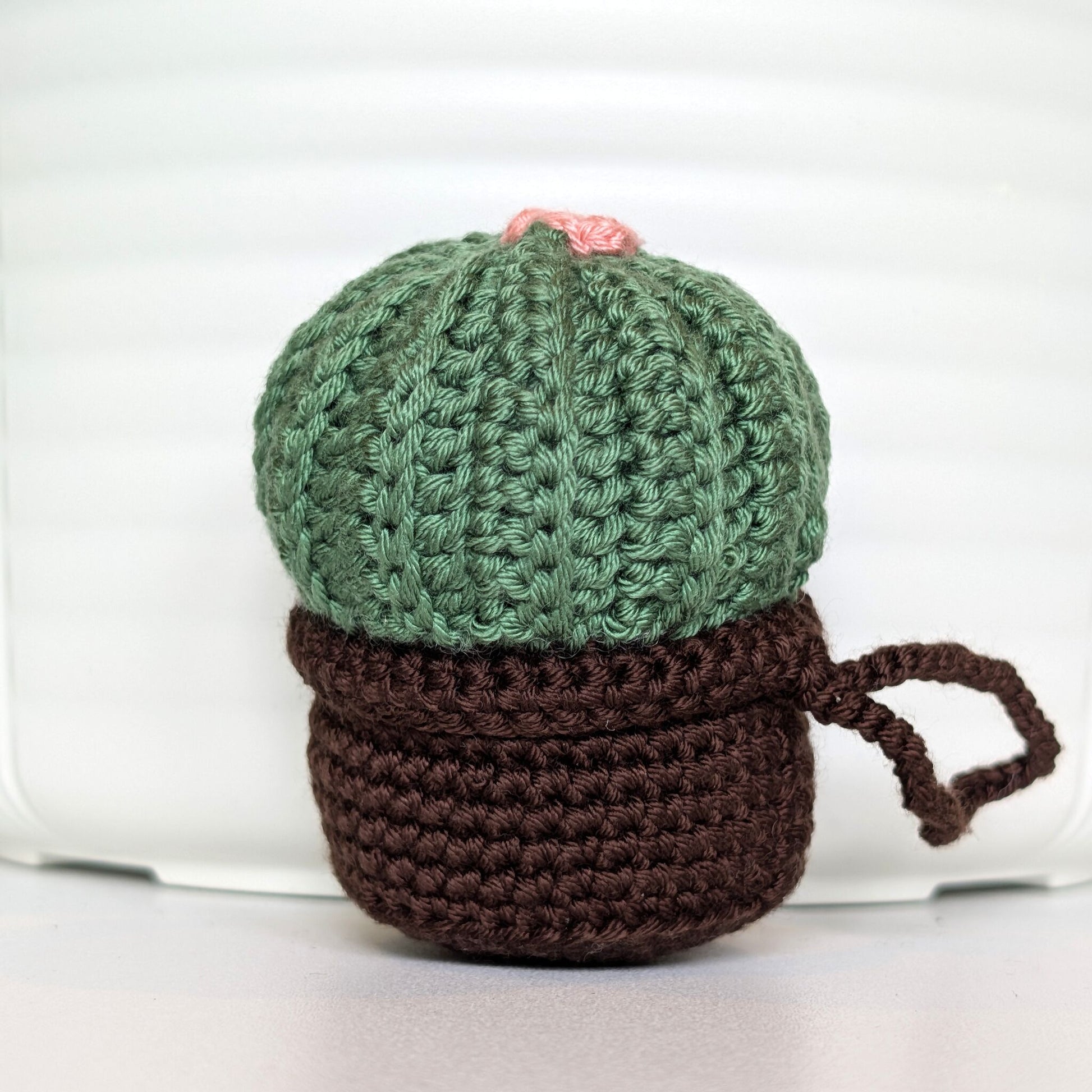 Crocheted moon cactus charm with a soft melon flower and attached string, potted in a brown pot