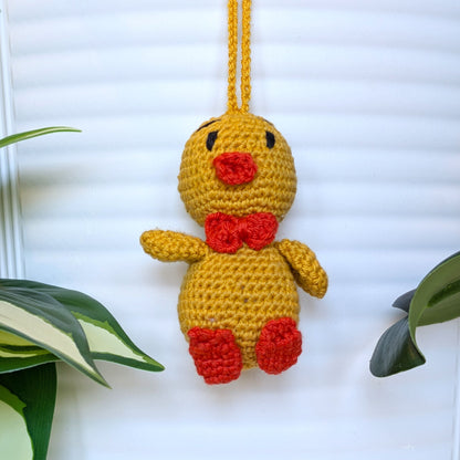 Crocheted golden yellow duck bag charm with string wearing bow tie