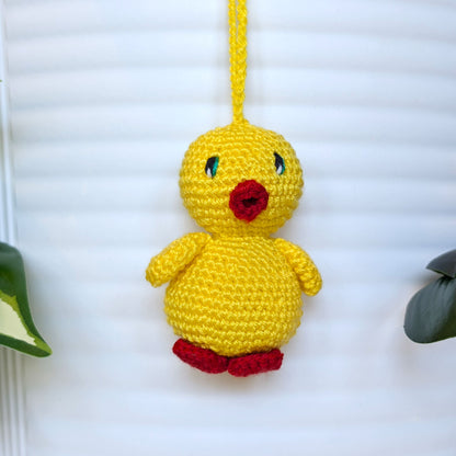 Crocheted yellow chick with jade green eyes, red beak and feet attached string 