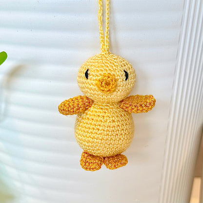 Crocheted light yellow chick with a string