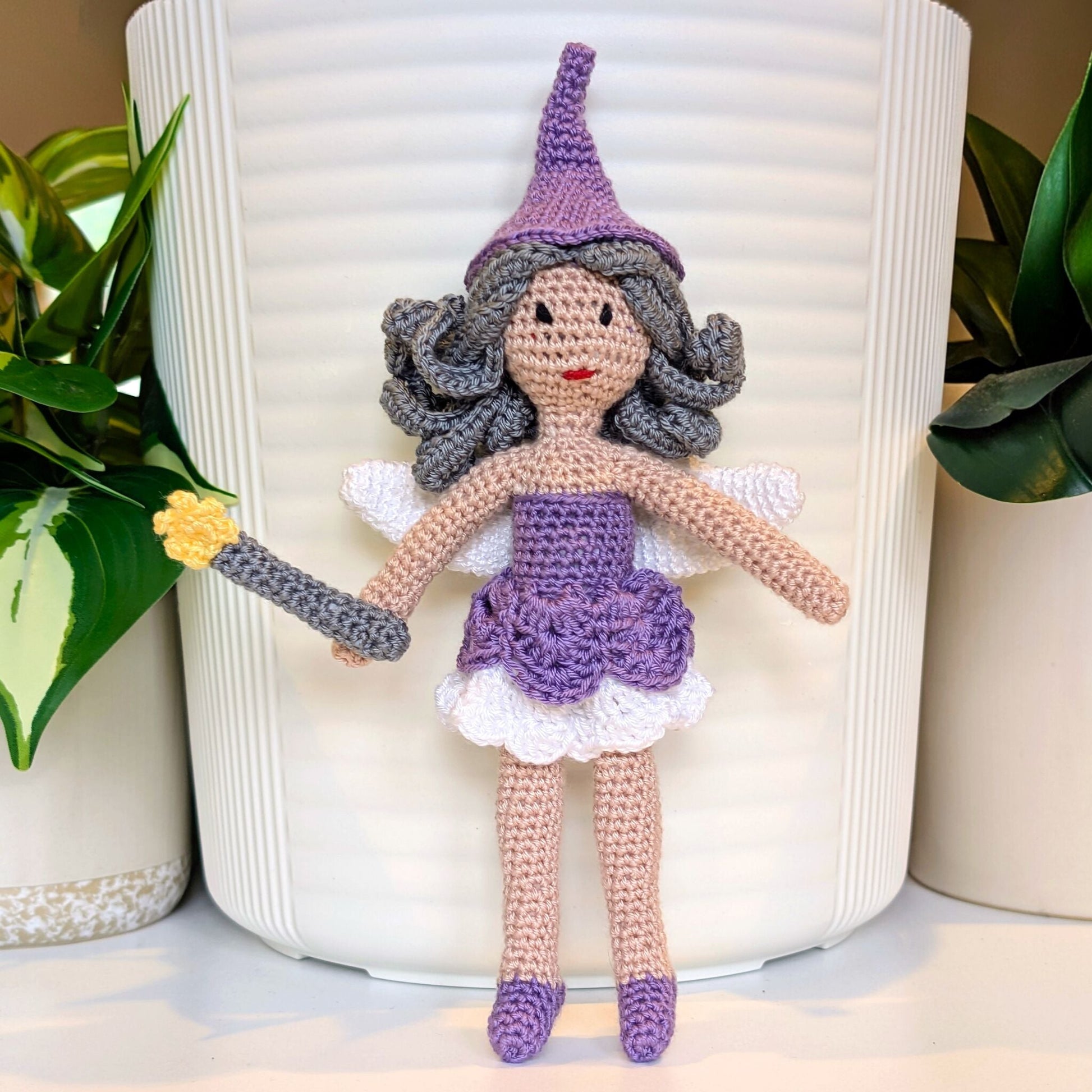 Crocheted fairy doll with a lavender outfit holding a wand