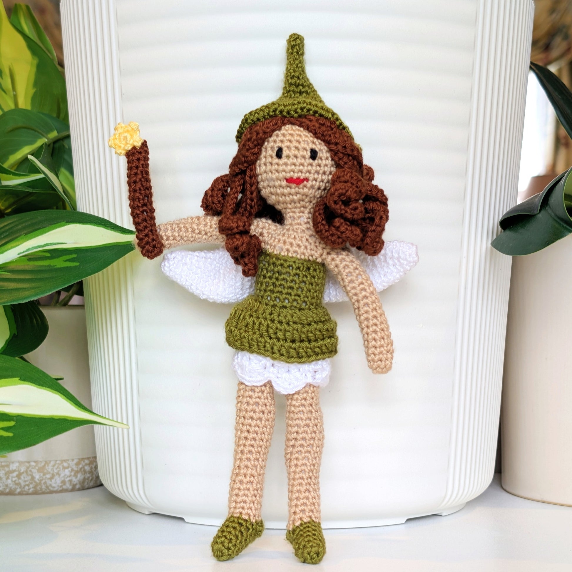 Crocheted fairy doll with green dress and hat, having brown hair holding a wand