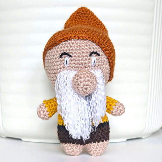 Handmade amigurumi garden gnome in terracotta brown hat, yellow shirt and beard