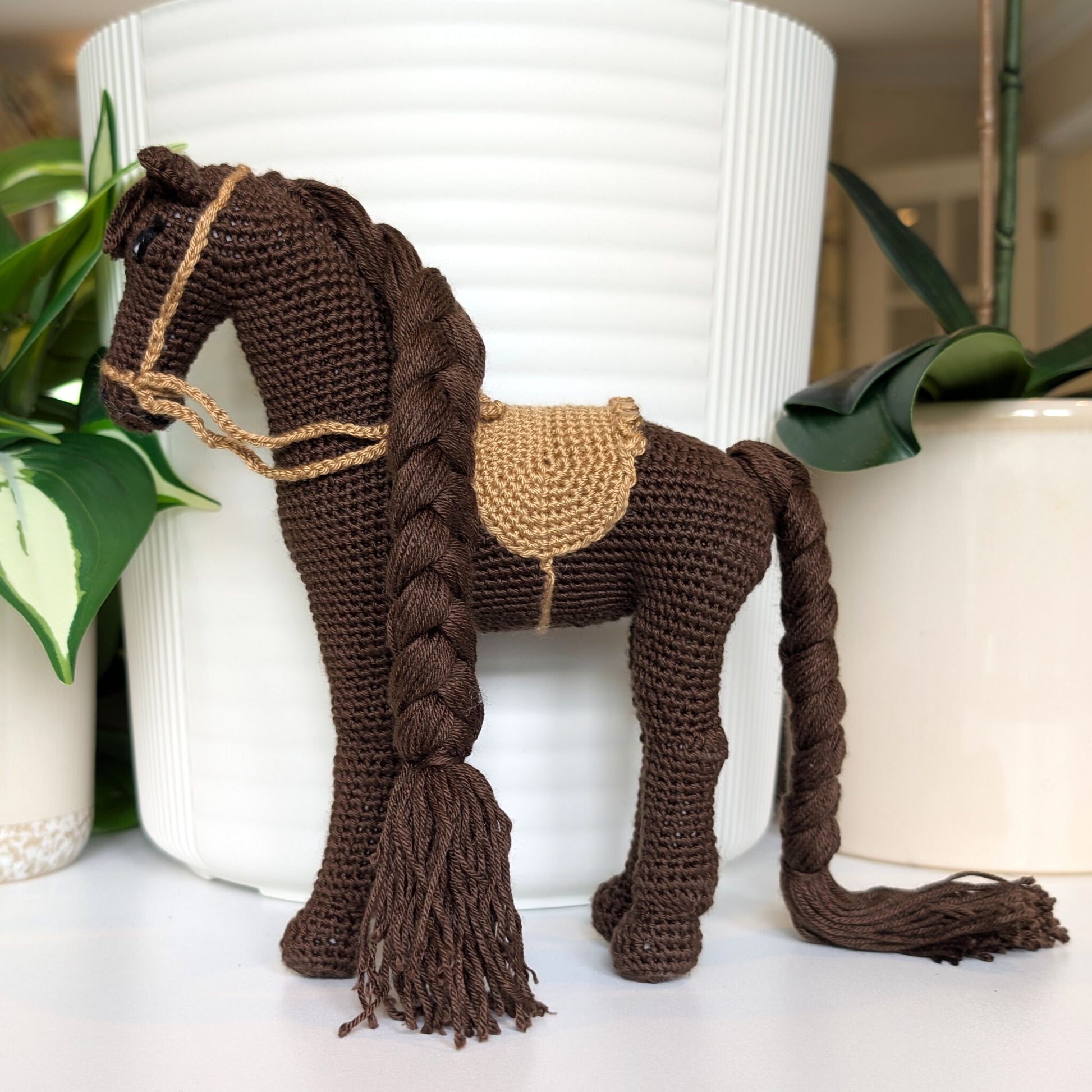 Crocheted horse plush with braided mane and tail with beige saddle
