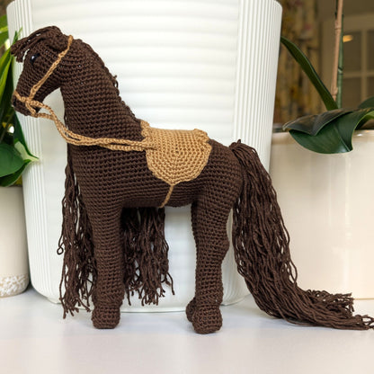 Crocheted brown horse with flowing mane and beige saddle