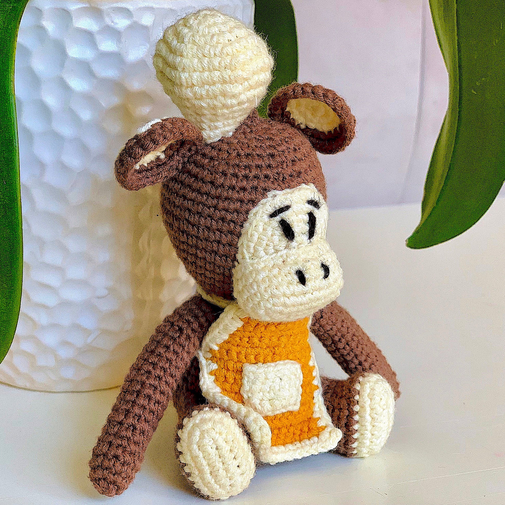 Crocheted plush monkey toy dressed like a chef.