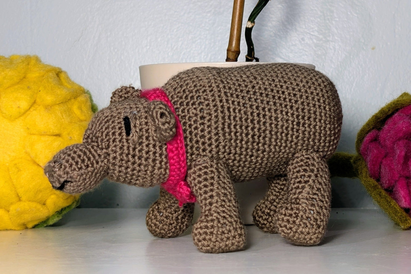 Knitted hippo toy with a pink bow