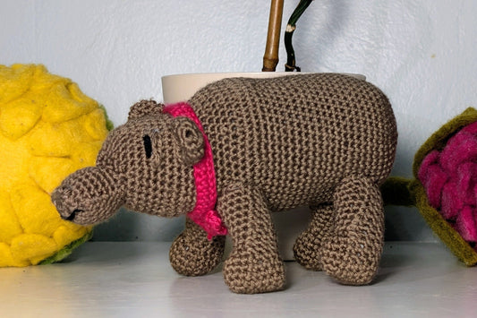 Knitted hippo toy with a pink bow