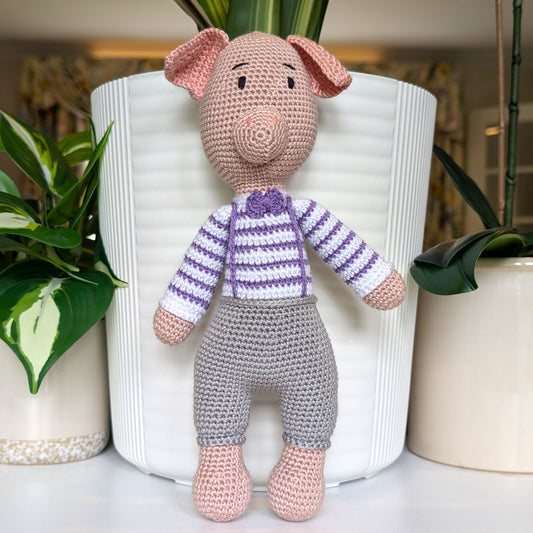 Crocheted standing pig wearing a striped lavender sweater, gray pants and a bow tie