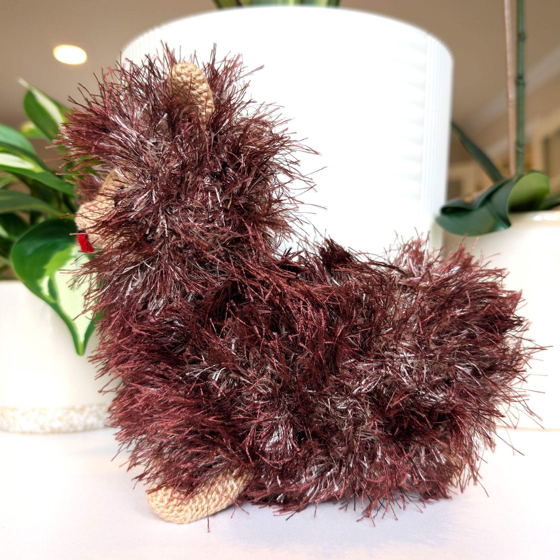Side view of crocheted fluffy Pomeranian dog with burgundy and silver coat