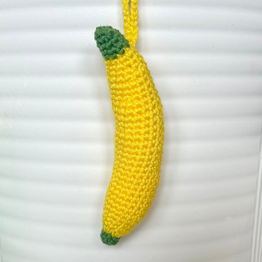 Crocheted yellow banana charm with a green stem