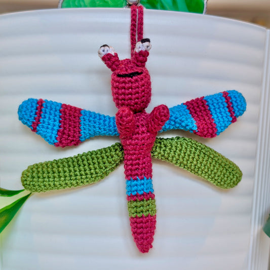 Small crocheted dragonfly bag charm with berry, moss green, and azure stripes