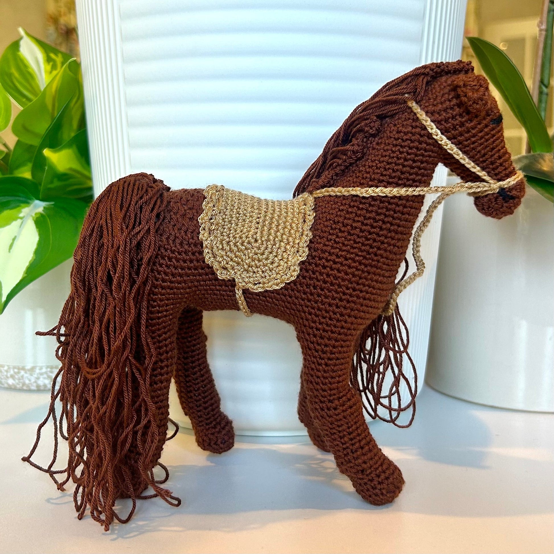 brown crocheted horse with a long flowing mane and a sand brown saddle
