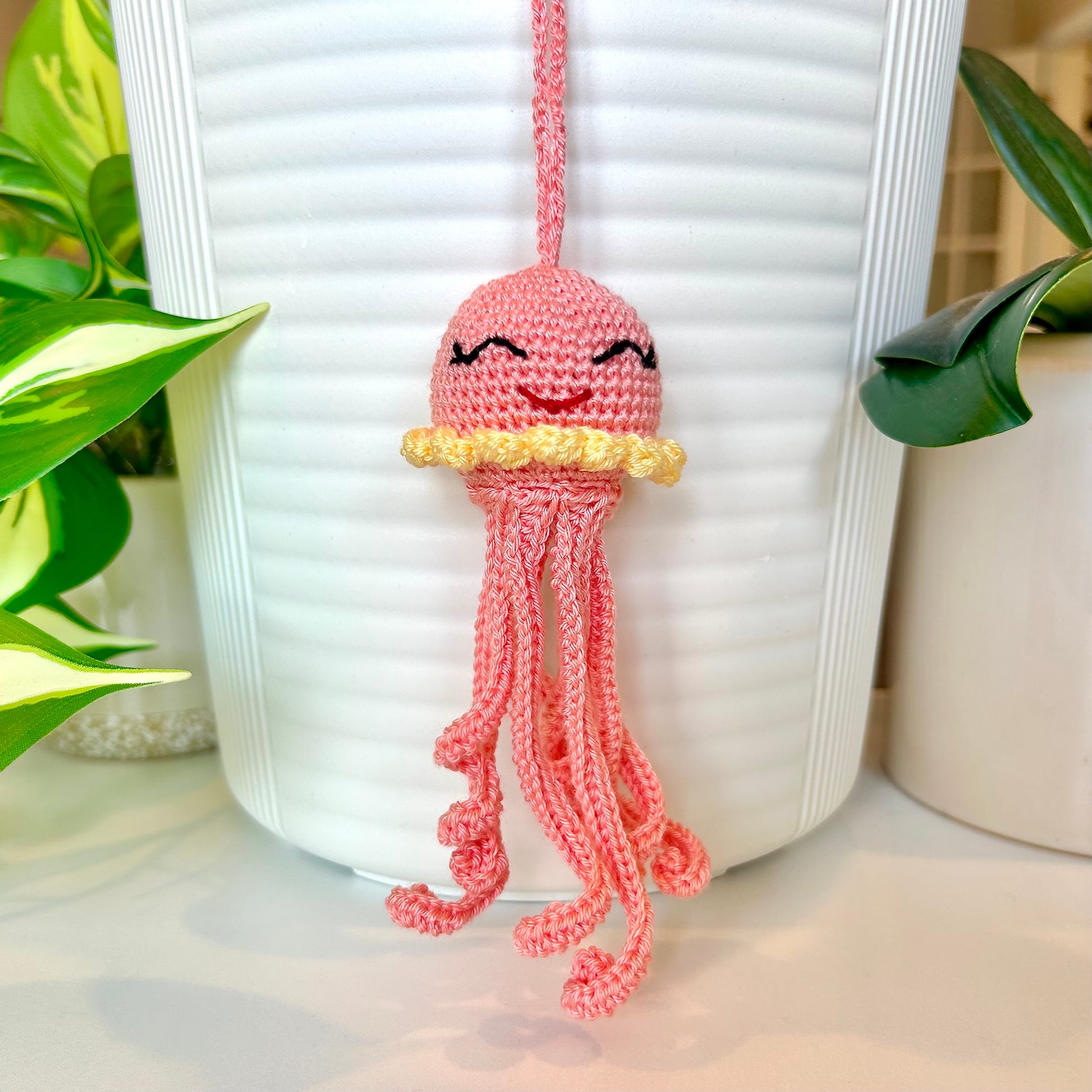 Crocheted coral-colored jellyfish bag charm with light yellow trim