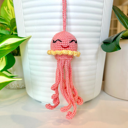 Crocheted coral-colored jellyfish bag charm with light yellow trim