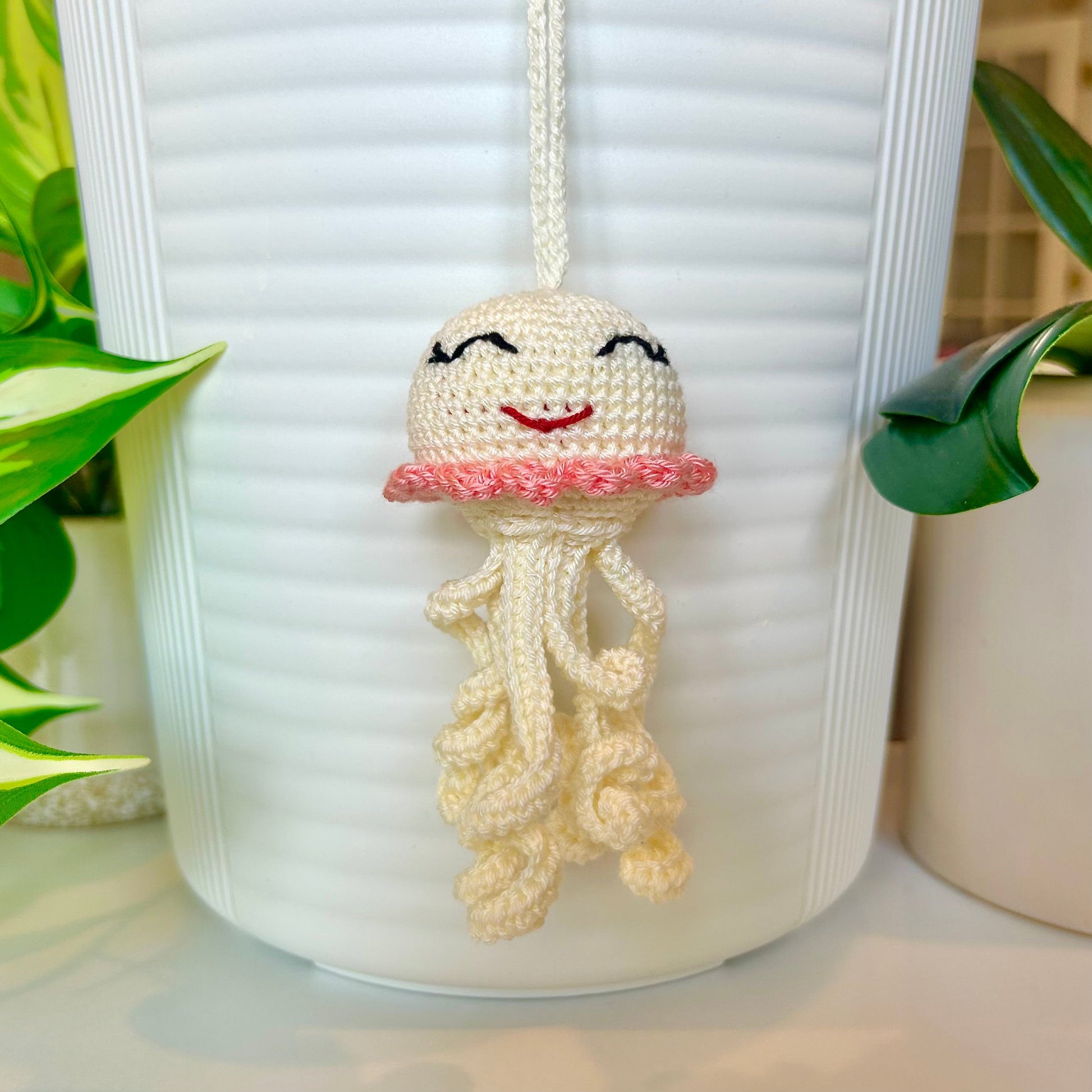 Crocheted cream jellyfish bag charm with coral trim