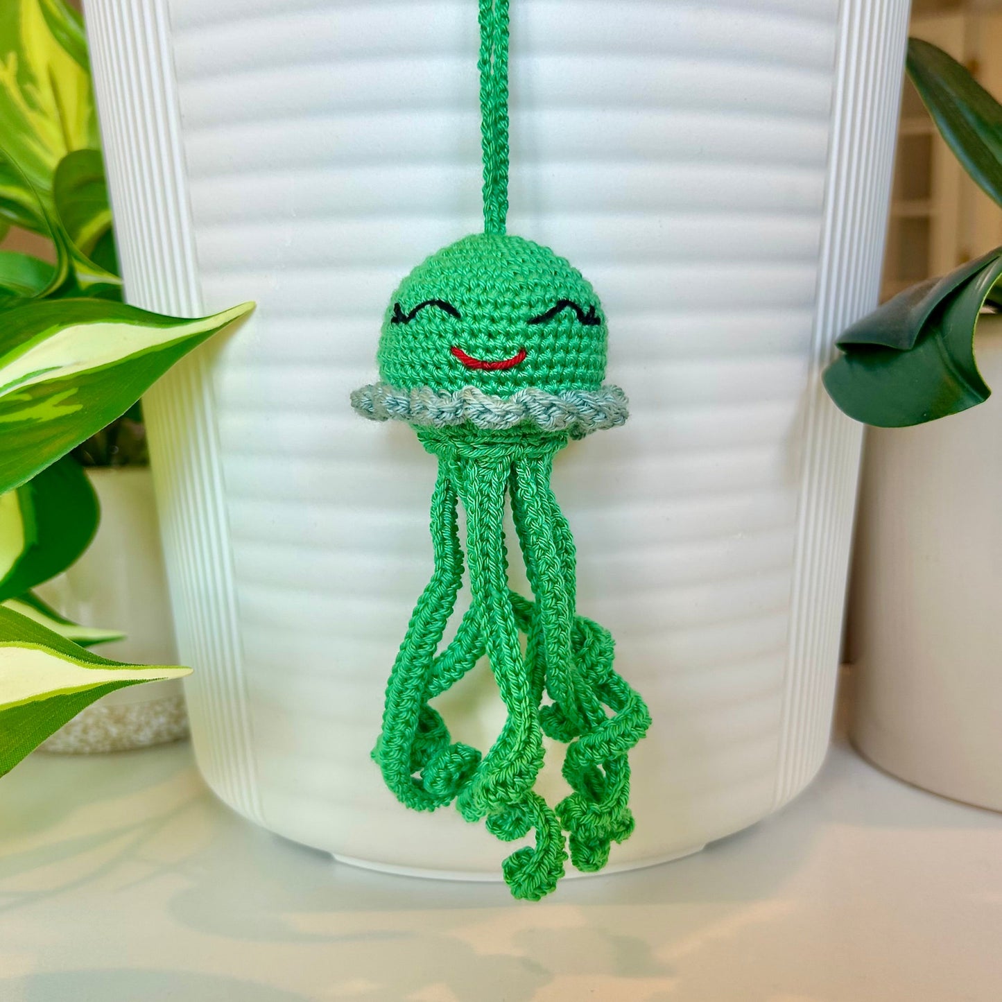 Crocheted emerald green jellyfish bag charm with seafoam blue trim