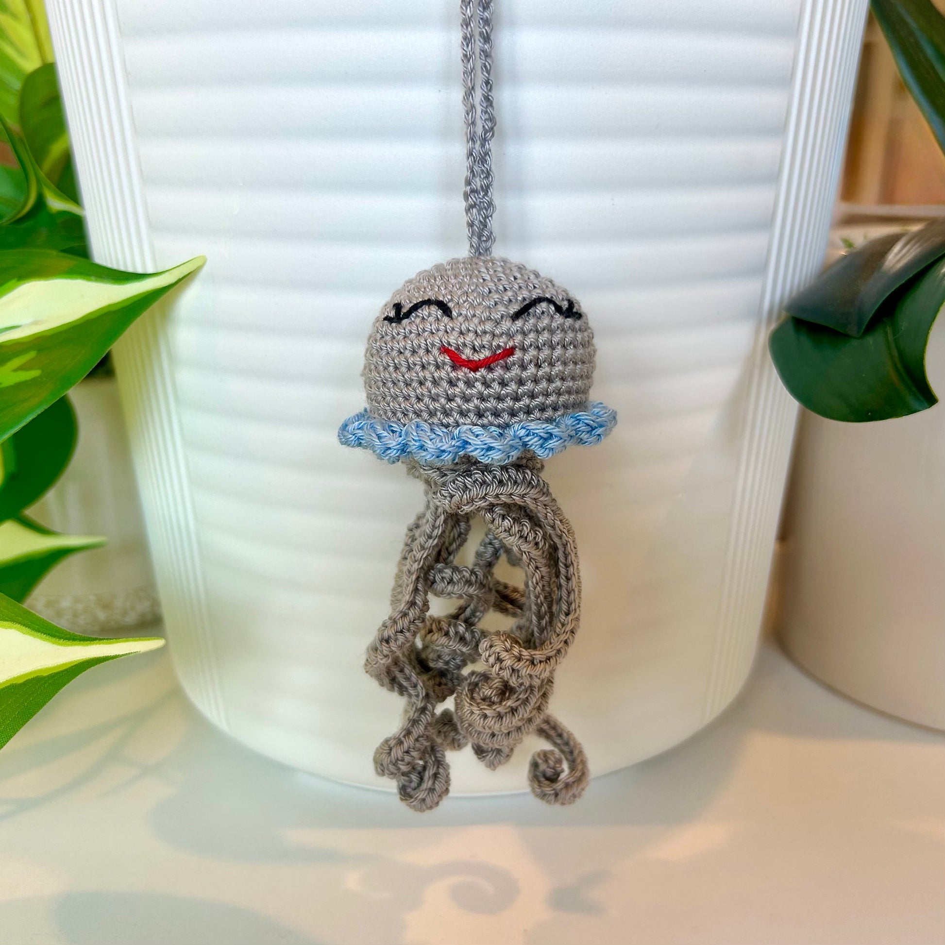 Crocheted gray jellyfish bag charm with light blue trim