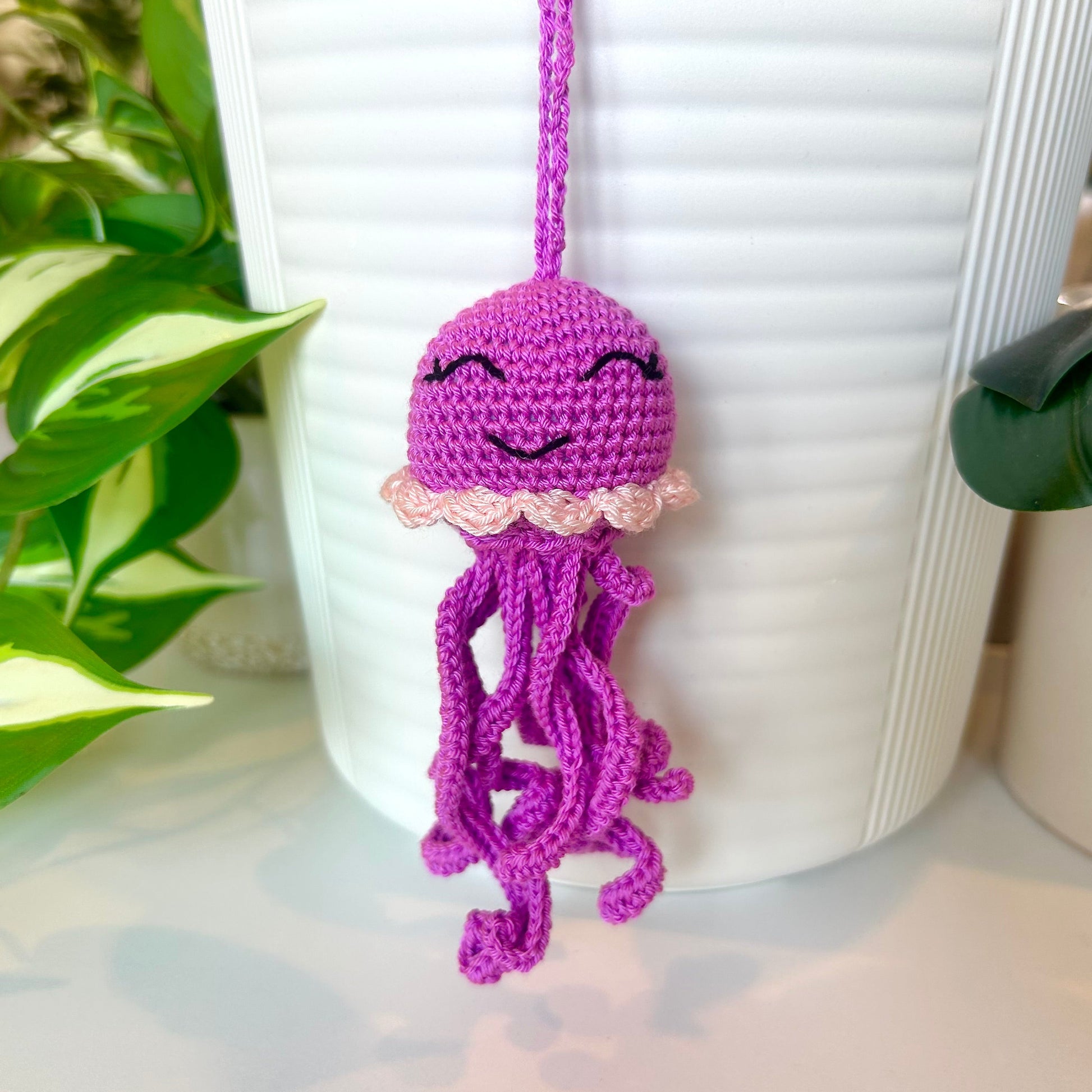 Crocheted orchid-colored jellyfish bag charm with pale pink trim
