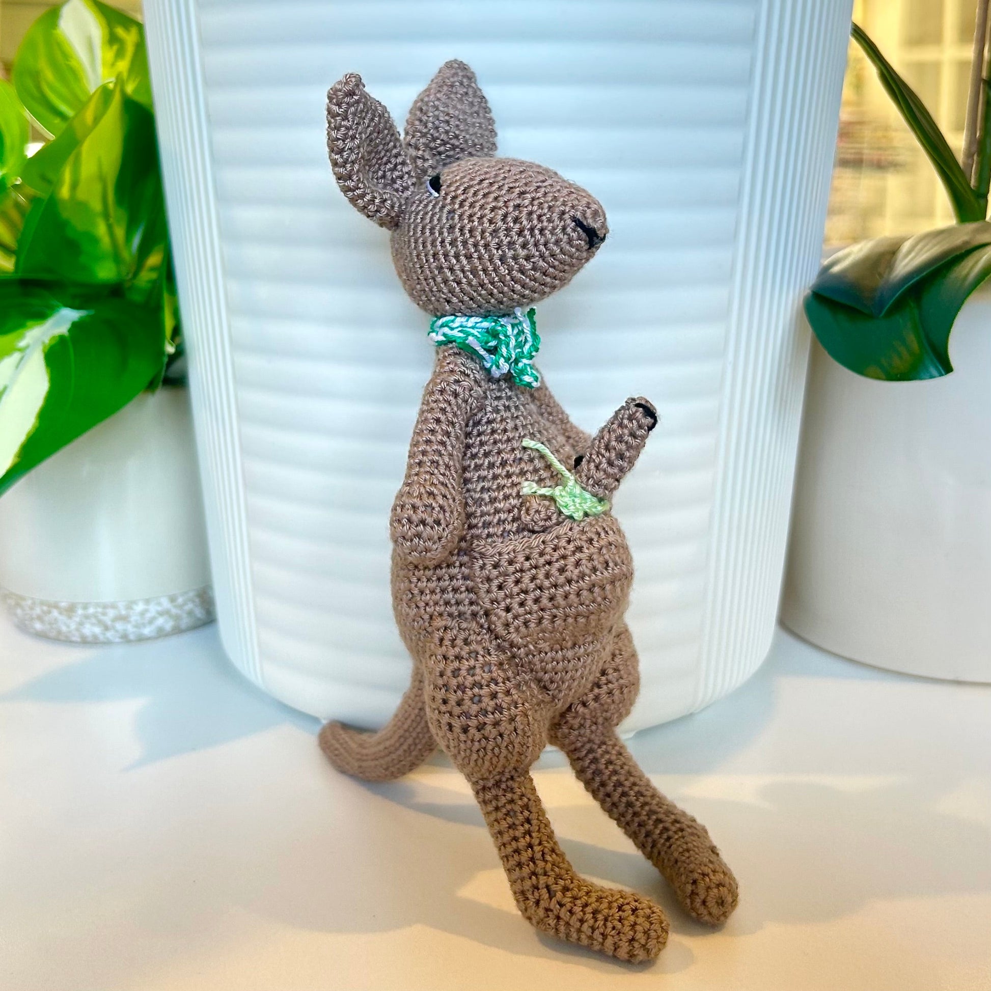 crocheted kangaroo wearing a jade and white scarf with a baby joey in her pouch wearing a mint green scarf