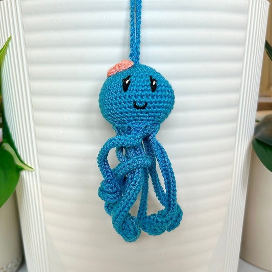 crocheted octopus charm in azure with a melon pink bow