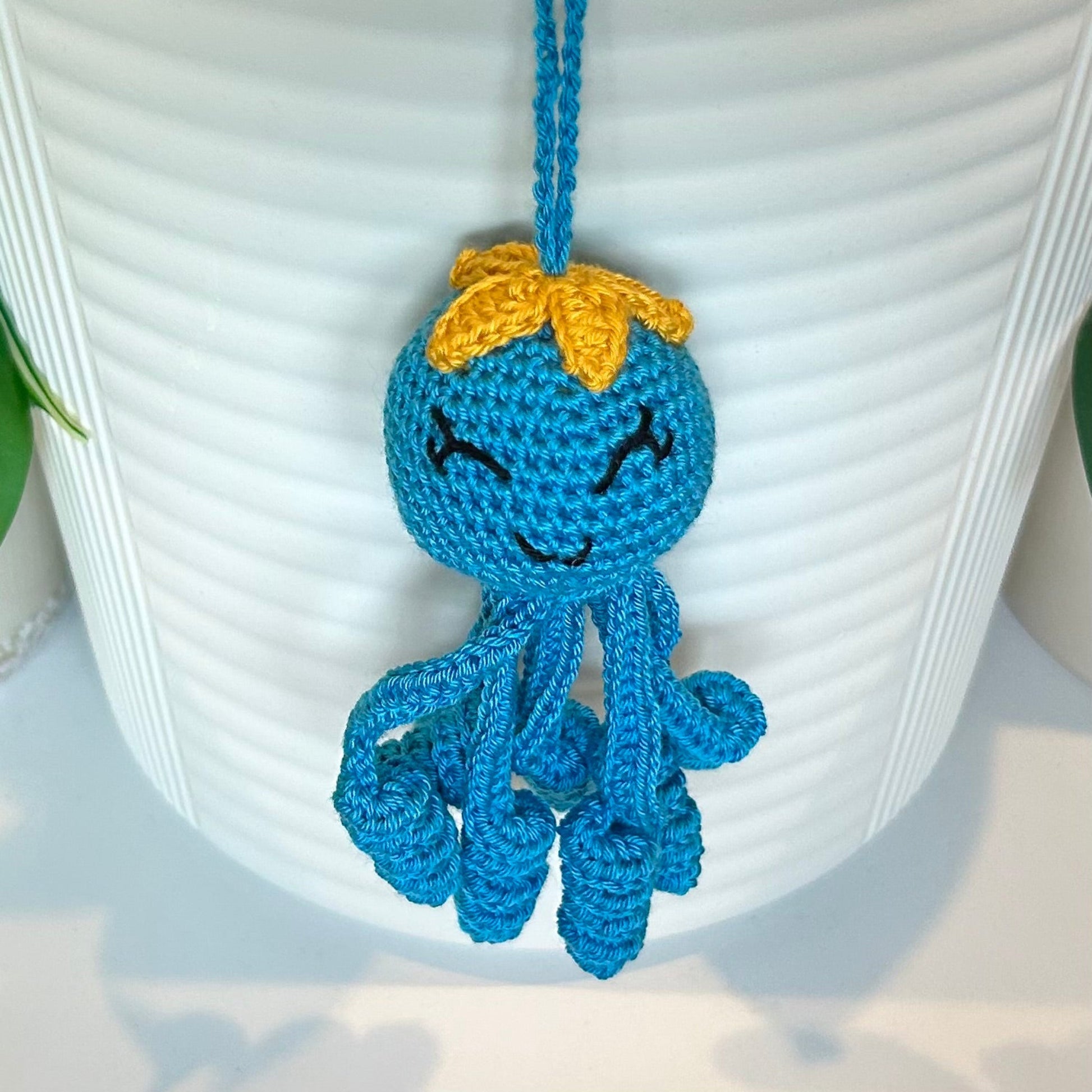 Crocheted Octopus charm in Azure with a large amber flower on its head