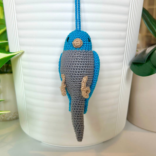 Crocheted parakeet charm with azure blue head and wings and gray body