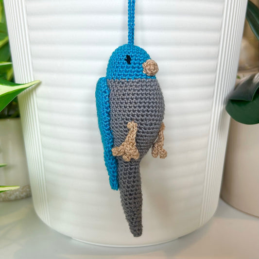 Right side profile of Crocheted parakeet charm with azure blue head and wings and gray body