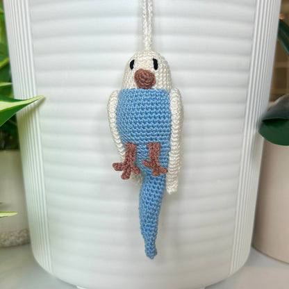 Crocheted parakeet charm with white wings and body and light blue body