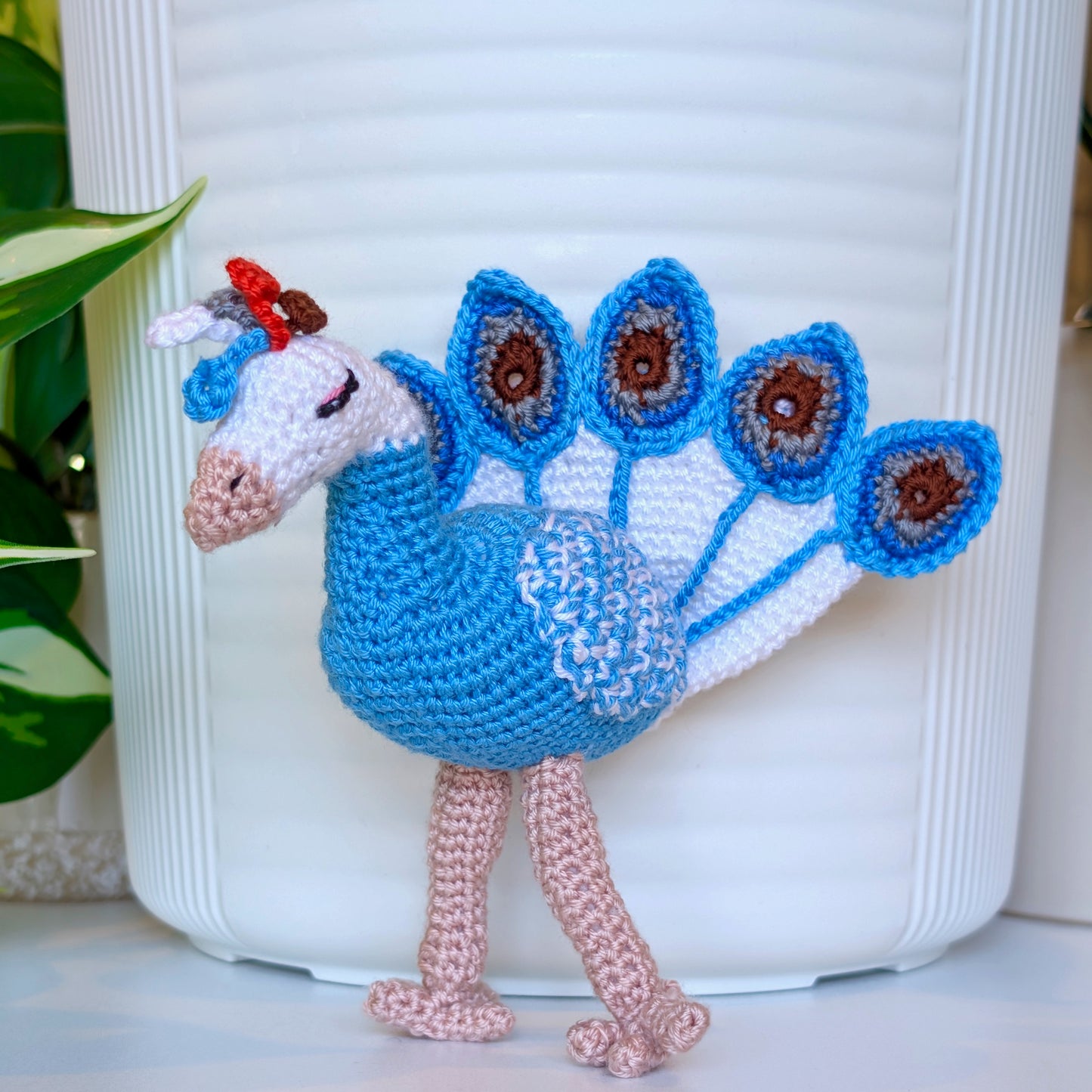 Crocheted peacock in Caribbean blue with white and brown accents