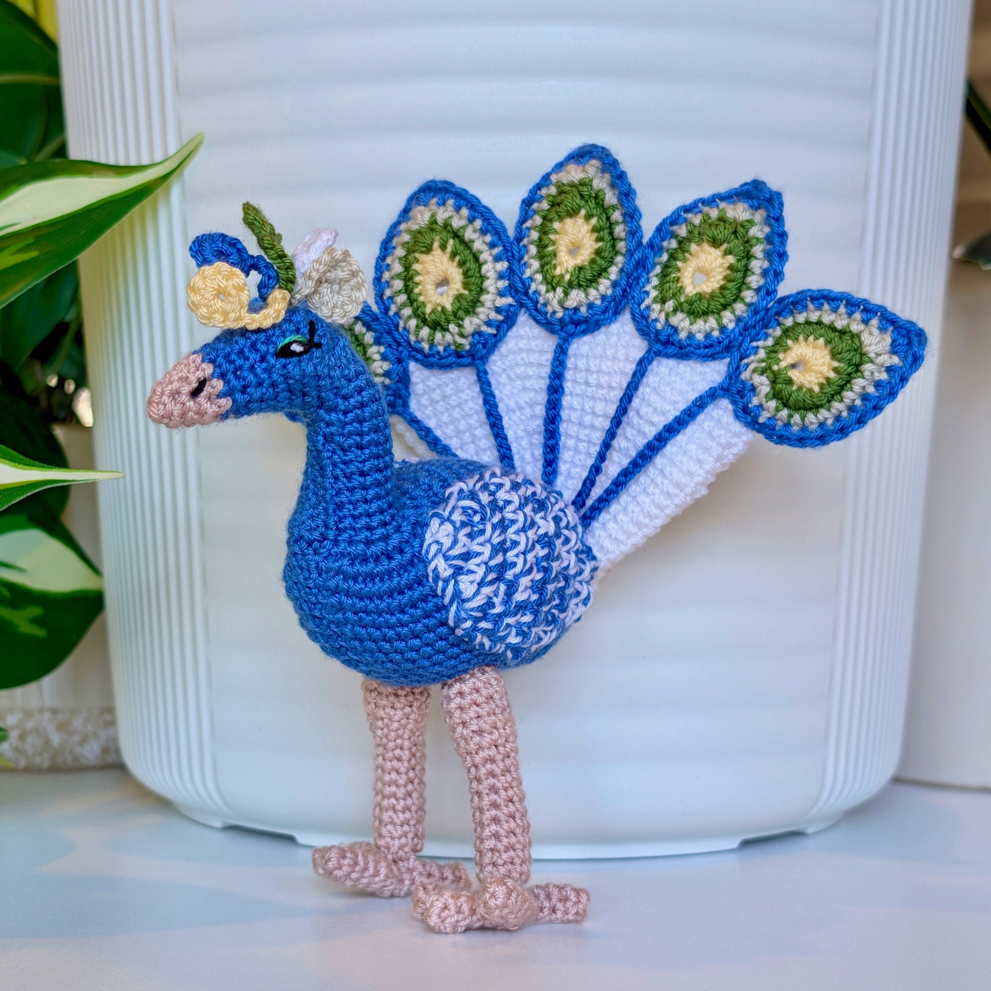 crocheted peacock in cobalt blue with white and moss green accents