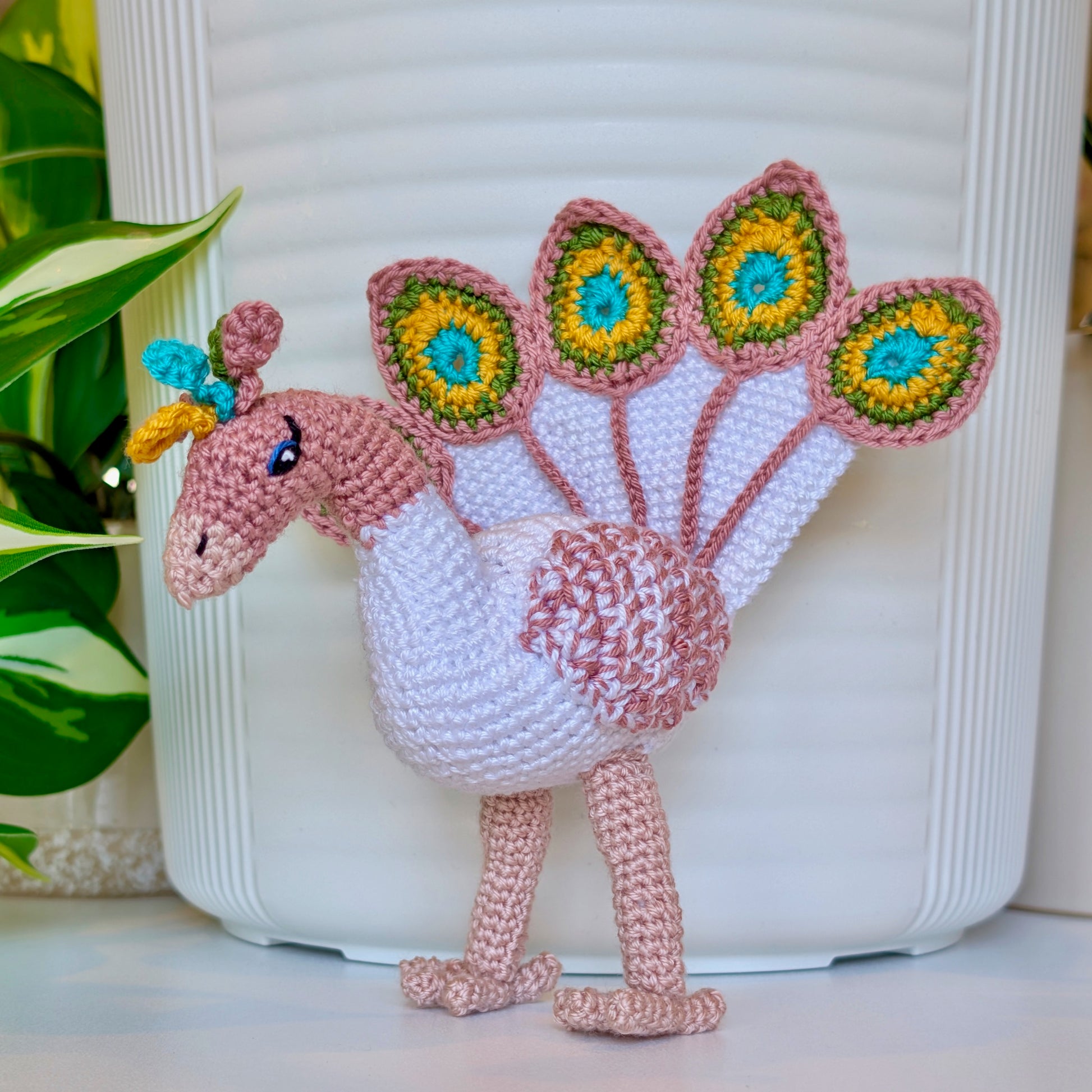 Crochet peacock in pastel rose with White, Sunflower yellow, and Turquoise accents