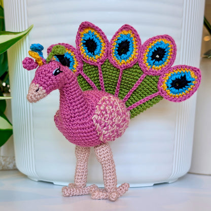 Crochet peacock in Wild Orchid with Moss Green, Caribbean Blue, and Sunflower Yellow accents